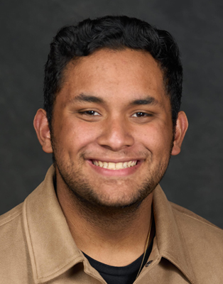 A man smiles while posing for a headshot.